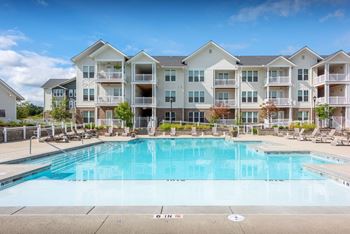 a swimming pool with an apartment building in the background